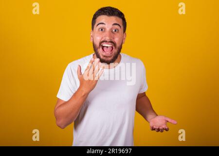 Homme brésilien d'Amérique latine, qui a l'air surpris, surpris, fond jaune Banque D'Images