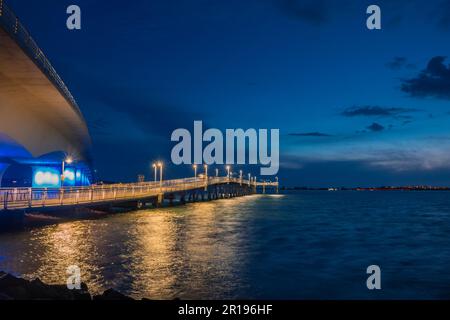 Sarasota, FL, US-10 avril 2023 : jetée de pêche dans la baie de Sarasota avec pont de Ringling en arrière-plan dans la soirée à des heures bleues avec un ciel spectaculaire. Banque D'Images