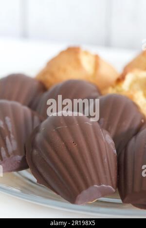 Muffins faits maison et biscuits Madeleine au chocolat. Ils reposent sur une plaque. Gros plan. Banque D'Images