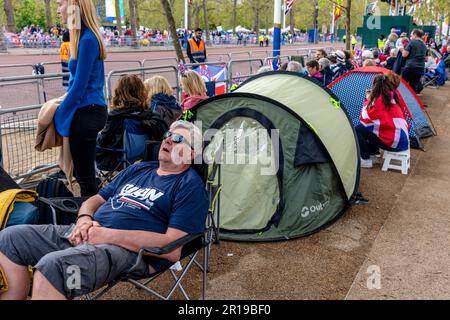 Les gens se rassemblent/campent dans le centre commercial pour regarder la procession du roi le jour avant le couronnement du roi Charles III, Londres, Royaume-Uni. Banque D'Images