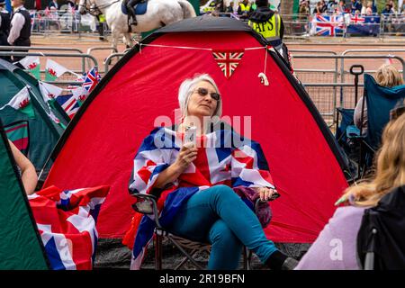 Les gens se rassemblent/campent dans le centre commercial pour regarder la procession du roi le jour avant le couronnement du roi Charles III, Londres, Royaume-Uni. Banque D'Images