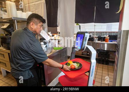 Troy, Michigan - Un robot Richtec Robotics Matradee livre de la nourriture aux convives du Pho-Shi, un restaurant fusion asiatique. Dans la cuisine, le propriétaire du restaurant va Banque D'Images