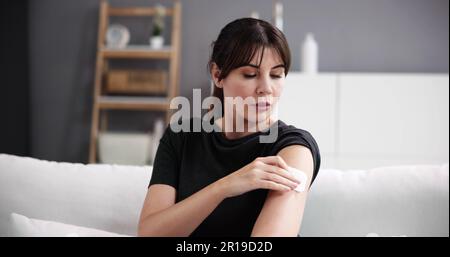 Femme avec un traitement patch de contraception sur le bras Banque D'Images