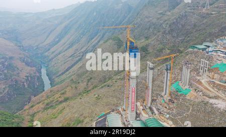 Qianxinan, Chine. 12th mai 2023. QIANXINAN, CHINE - 12 MAI 2023 - photo aérienne prise sur 12 mai 2023 montre le pont de la gorge de Huajiang en construction sur l'autoroute Liuzhi-Anlong à Qianxinan, province de Guizhou, Chine. Le pont Huajiang Canyon est un pont suspendu à poutres en acier d'une longueur totale de 2 890 mètres et d'une portée principale de 1 420 mètres. La différence de hauteur verticale entre le plancher du pont et la surface de l'eau est de 625 mètres. Le pont devrait être terminé en 2025. (Photo par Costfoto/NurPhoto) crédit: NurPhoto SRL/Alay Live News Banque D'Images