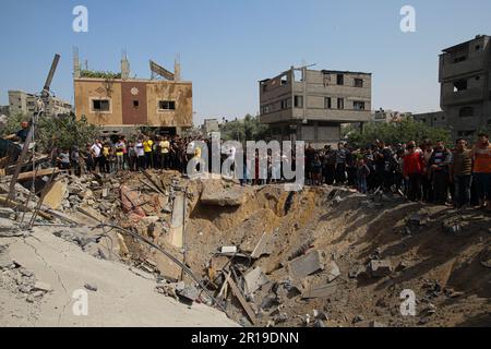 Gaza, Palestine. 12th mai 2023. Les Palestiniens se réunissent près d'un bâtiment détruit appartenant à la famille Taha après les attaques israéliennes dans le camp de Jabalia, au nord de Gaza, à Gaza, sur 12 mai 2023. Photo de Ramez Habboub/ABACAPRESS.COM crédit: Abaca Press/Alay Live News Banque D'Images