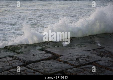 Des vagues méditerranéennes frappent les pierres à Alexandrie, en Égypte Banque D'Images