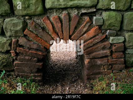 Cheminée voûtée de carreaux transportant l'air chaud d'un four à charbon externe dans la salle de bain du commandant au fort romain de Chesters, mur d'Hadrien, Royaume-Uni. Banque D'Images