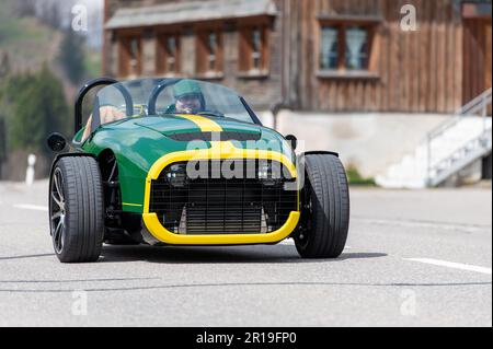 L'homme dans un roadster vert à trois roues dans le village de Gams. Banque D'Images