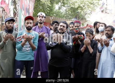 Les activistes de Tehreek-e-Insaf (PTI) offrent vendredi à Dua pour l'Imran Khan, chef PTI pour sa sécurité, au parc Zaman de Lahore, à 12 mai 2023. Banque D'Images