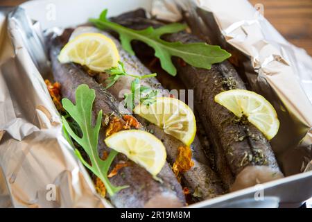 Poisson cru avec assaisonnements et épices préparés pour cuire au four en feuilles, sous forme de céramique. Banque D'Images