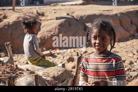 Ilakaka, Madagascar - 30 avril 2019: Petite fille aux cheveux tressés posant pour les touristes un autre enfant en arrière-plan. Le peuple de Madagascar, en particulier Mal Banque D'Images