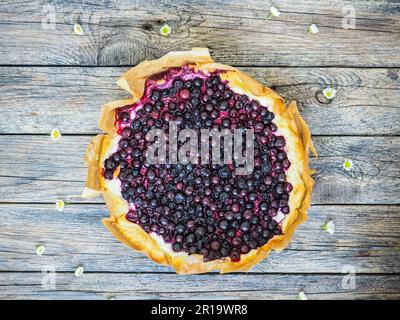 Tarte au cassis fraîchement cuite. Tarte maison ouverte avec des baies d'été sur une table en bois. Vue de dessus. Tarte aux baies. Pâtisseries gourmandes, traditionnelles Banque D'Images