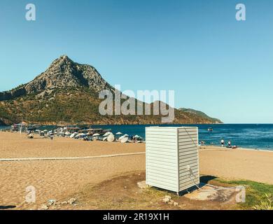 sur le bord de mer il y a une boîte blanche en bois. mer avec une plage de sable sur fond de montagne. dans une cabine en bois un dressing pour à Banque D'Images