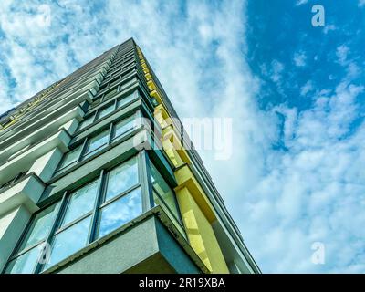 bâtiment de grande hauteur. coin de la maison avec verre et fenêtres panoramiques, murs de blocs. bâtiment moderne de grande hauteur pour la vie des gens. Banque D'Images