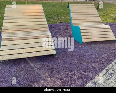 De magnifiques bancs et chaises longues branchés dans la cour de la maison dans le parc et l'espace public pour s'asseoir et se détendre sur le pébb pourpre Banque D'Images