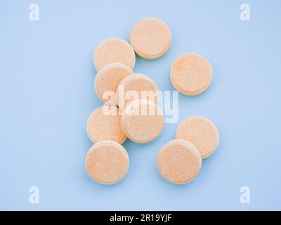 Vitamines effervescentes solubles avec saveur orange sur fond bleu. Santé et médecine. Gros plan. Vitamine, minéral, supplément nutritionnel pour Banque D'Images