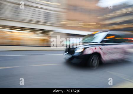 Un taxi londonien en voiture. Prise de vue utilisant une longue exposition pour créer un flou de mouvement Banque D'Images