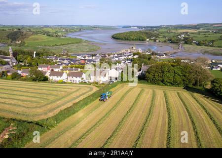 Timoleague, West Cork, Irlande. 12th mai 2023. Barry long, d'Eoin Coomey Agri & Plant LTD, balle de l'herbe pour John Michael Foley, agriculteur basé à Timoleague, en utilisant un tracteur New Holland T7,245 et une presse McHale Fusion 3 plus. Le village côtier de Timoleague et son estuaire sont illustrés en arrière-plan. Crédit : AG News/Alay Live News Banque D'Images