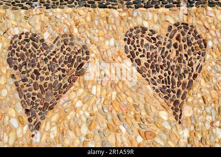 La texture du mur de pierre, la route de petites pierres rondes et ovales avec des lignes abstraites de motifs de deux coeurs sablonneux coutures du vieux ye naturel Banque D'Images