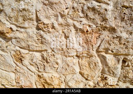 Texture d'un mur de pierre, routes de pierres, briques, pavés, tuiles avec des coutures de sable de gris ancien naturel jaune avec des bords tranchants. Le dos Banque D'Images