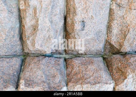 Texture en pierre immense, robuste, surélevée, convexe, naturelle, granit de la paroi torchée avec des coutures et des fissures. L'arrière-plan. Banque D'Images