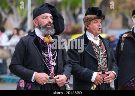 Des hommes sardes vêtus de costumes traditionnels folkloriques, avec des éléments uniques représentant la région d'où ils viennent, se joignent au festival de la fête de Saint Efisio Banque D'Images