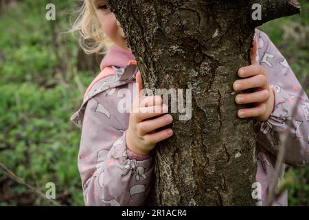 Embrasser un arbre: La fille se sent calme et harmonieuse, appréciant la thérapie forestière qui stimule et restaure l'âme Banque D'Images