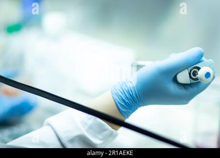 Un chimiste portant des gants de protection menant une expérience scientifique en laboratoire Banque D'Images