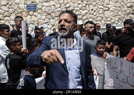 Les parents et les amis du jeune Thaer Bakirat participent à la manifestation contre le tir du jeune Bakirat, qui est actuellement sous traitement à l'hôpital Hadassah Ein Kerem pendant qu'il est en état d'arrestation. Une veillée et une manifestation ont eu lieu dans la ville de sur Baher après que Thaer Bkerat, âgé de 19 ans, ait été abattu trois fois par la police israélienne à la fin de la nuit de mercredi. Il a été capturé après avoir été tourné à une plage de points-vides. Il a été renvoyé pour traitement pendant sa détention. La famille Bakirat a expliqué que 3 balles pénétraient le corps de leur fils, « les poumons, la jambe et la main ». Banque D'Images