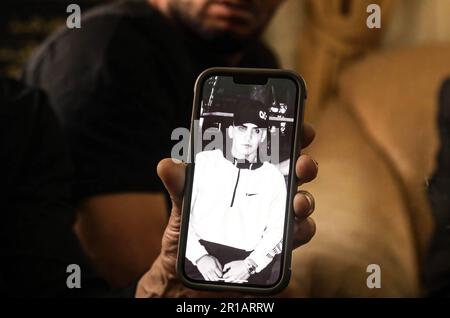 Le père du jeune Thaer Bakirat (Shehadeh Bakirat) montre les photos de son fils dans la maison familiale de la ville de sur Baher, après que la police l'a empêché de rendre visite à son fils à l'hôpital Hadassah Ein Kerem où il est actuellement sous traitement alors qu'il est en état d'arrestation. Une veillée et une manifestation ont eu lieu dans la ville de sur Baher après que Thaer Bkerat, âgé de 19 ans, ait été abattu trois fois par la police israélienne à la fin de la nuit de mercredi. Il a été capturé après avoir été tourné à une plage de points-vides. Il a été renvoyé pour traitement pendant sa détention. La famille Bakirat a expliqué que 3 balles pénétraient leur s Banque D'Images