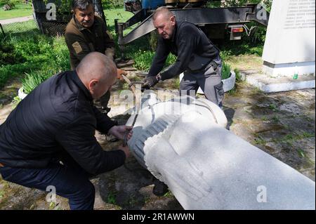 Village Pnikut, Ukraine. 12th mai 2023. Des ouvriers démantelent le monument soviétique à une mère en deuil et un bas-secours d'un soldat soviétique à des soldats soviétiques morts dans la Seconde Guerre mondiale L'Ukraine fait des efforts pour effacer les traces de l'influence soviétique et russe de l'espace public, démolissant des monuments et renommant des centaines de rues en l'honneur des artistes, des poètes et des chefs militaires de l'ère soviétique. (Photo de Mykola TYS/SOPA Images/Sipa USA) crédit: SIPA USA/Alay Live News Banque D'Images