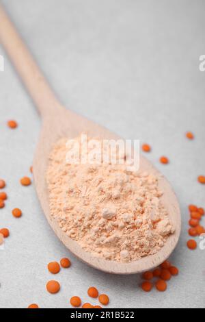 Cuillère de farine de lentilles et de graines sur table blanche, gros plan Banque D'Images