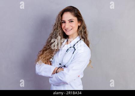 Portrait de confiant avec le sourire ensanglant qualifié intelligent expérimenté médecin portant blanc tenue formelle elle est debout avec croisé Banque D'Images