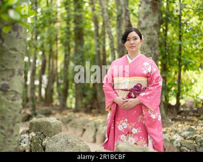 Belle jeune race mixte japonaise / américaine portant un kimono debout sur le sentier de Bise Village, Motobu Town, Okinawa, Japon. Banque D'Images