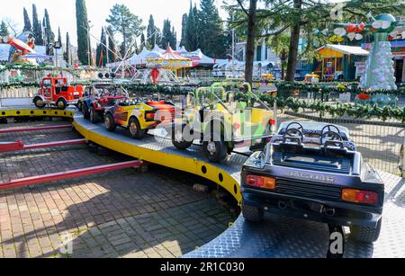 Carrousel pour enfants avec voitures jouets dans le parc d'attractions Banque D'Images