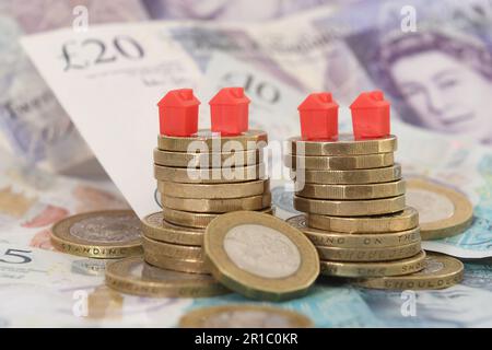 Photo du fichier datée du 12/09/18 de maisons modèles sur un tas de pièces de monnaie et de billets de banque, car il ya plus de douleur hypothécaire à venir pour les propriétaires britanniques, dont beaucoup sont encore de sentir l'impact complet de la hausse des taux d'intérêt, selon un think tank. Banque D'Images