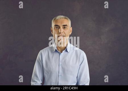 Portrait d'un homme d'âge moyen sérieux sur fond noir Banque D'Images