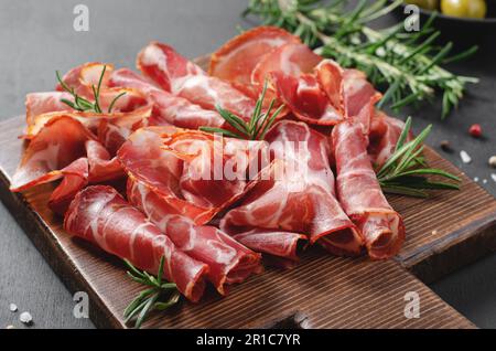 Plat de viande séchée, antipasti, hors-d'œuvre sur fond sombre de boardover Banque D'Images