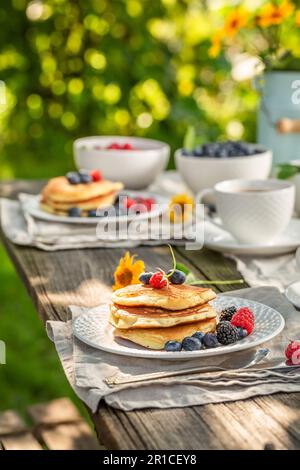 Crêpes américaines fraîches et chaudes servies avec café dans le jardin. Petit déjeuner dans le jardin de printemps. Banque D'Images