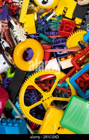 Une abondance de jouets dans la chambre des enfants, beaucoup de pièces en plastique multicolores de designers, pièces de rechange pour jouets, figurines et cubes. Banque D'Images