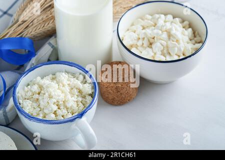 Fête juive de Shavuot. Kasher produits laitiers frais lait et fromage, blé mûr, crème sur fond de bois blanc. Les produits laitiers sur le whi Banque D'Images