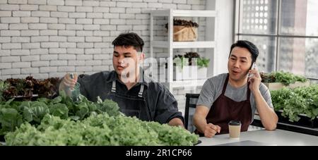 Le vendeur de légumes a fêté avec son personnel la réception d'un grand nombre de commandes par téléphone. Cela a le potentiel de générer des revenus élevés et pro Banque D'Images