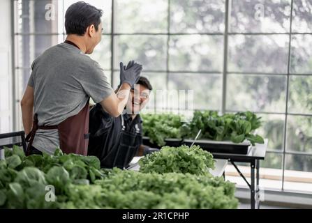 Le vendeur de légumes a fêté avec son personnel la réception d'un grand nombre de commandes par téléphone. Cela a le potentiel de générer des revenus élevés et pro Banque D'Images