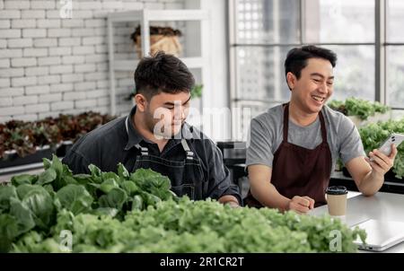 Le vendeur de légumes a fêté avec son personnel la réception d'un grand nombre de commandes par téléphone. Cela a le potentiel de générer des revenus élevés et pro Banque D'Images