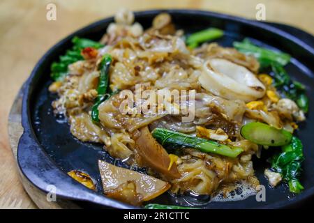 Incorporer les nouilles frites et la sauce soja servies dans la poêle. Style thaïlandais Banque D'Images