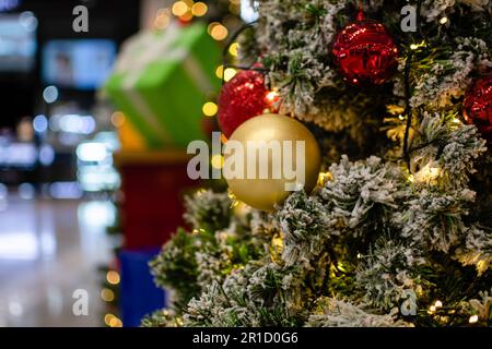 Gros plan de boules dorées de taille moyenne arbre de Noël décoré avec de petites ampoules est magnifique. Décoration d'arbre de Noël avec neige blanche, espace de copie sur la gauche pour Banque D'Images