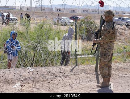 El Paso, États-Unis. 11th mai 2023. Les gens regardent de l'autre côté de la frontière du Mexique les soldats de la garde nationale de l'armée du Texas avec les gouverneurs autostylisés de la Force frontalière tactique du Texas, pendant l'opération Lone Star Task Force West, 11 mai 2023 près d'El Paso, Texas. La crainte d’une vague de migrants après l’expiration du titre 42 ne s’est pas concrétisée avec moins de migrants risquant les sanctions plus sévères prévues par les nouvelles règles du titre 8. Crédit : Mark Otte/Texas National Guard/Alay Live News Banque D'Images