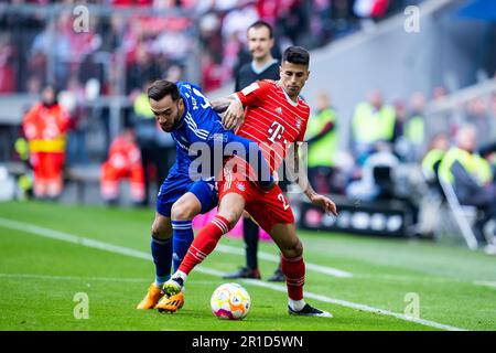 Munich, Allemagne. 13th mai 2023. Football: Bundesliga, Bayern Munich - FC Schalke 04, Matchday 32, Allianz Arena. Kenan Karaman de Schalke (l) en action contre Joao Cancelo (r) de Munich. Crédit : Tom Weller/dpa - REMARQUE IMPORTANTE : Conformément aux exigences de la DFL Deutsche Fußball Liga et de la DFB Deutscher Fußball-Bund, il est interdit d'utiliser ou d'avoir utilisé des photos prises dans le stade et/ou du match sous forme de séquences et/ou de séries de photos de type vidéo./dpa/Alay Live News Banque D'Images