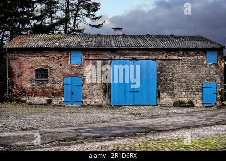 Une ancienne grange abandonnée avec des portes peintes en bleu clair. Banque D'Images