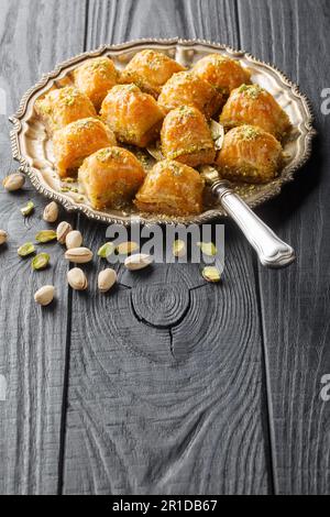 Baklava turque au beurre, pâte feuilletée trempée dans le miel et le sucre avec des pistaches tendres farcies entre les couches de pâte de la plaque Banque D'Images